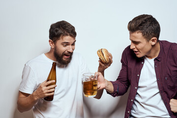 Two cheerful friends drinking beer drunk fun lifestyle communication light background