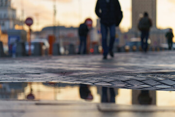 Blurred motion. Moscow autumn street and people  had been reflected at the water surface of puddles. Lifestyle concept. Theme of urban beauty.
