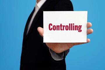 Controlling. Geschäftsmann im Anzug zeigt Karte mit Text. Mann isoliert vor Hintergrund (blau)