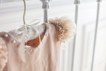 Beige dress from wool and openwork details on a white background. Handmade sute for baby girl weighs on a hanger