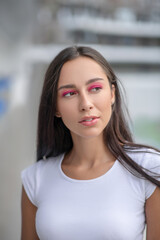 Dark-haired girl in white tshirt looking thoughtful