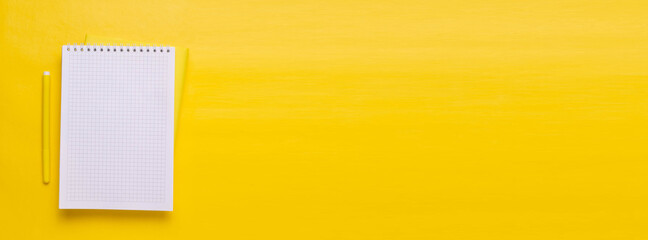 White Notepad and yellow pen on a yellow background. Minimalism.