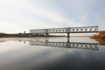 Fototapeta premium Railway bridge over the river Sozh in the sunset sunlight. Gomel. Belarus.