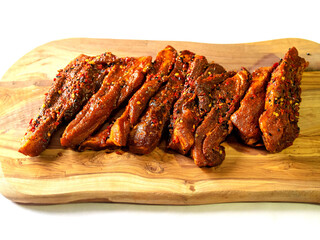 Fresh unclooked pork belly slices on a wooden board, Meat marinated in Korean style marinate. Meat industry product.