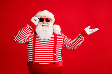 Fototapeta na wymiar Portrait of his he nice attractive handsome cheerful cheery Santa demonstrating copy space gift present surprise bargain offer isolated on bright vivid shine vibrant red color background