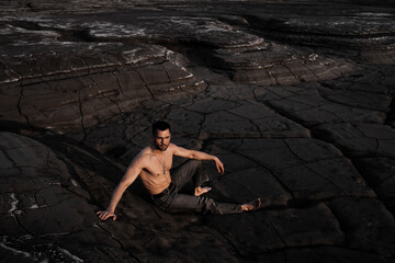 Attractive tanned man on the black sand
