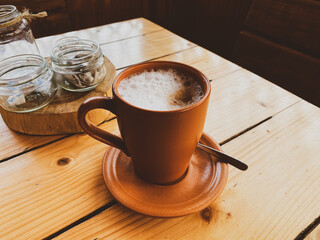 coffee in a clay cup on a wooden table