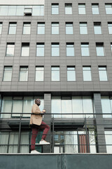 African businessman standing against the modern office building in the city