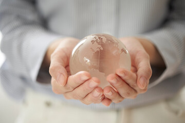 透明の地球儀を持つ女性の手元