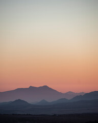 landscape of a sunrise with mountains and fields