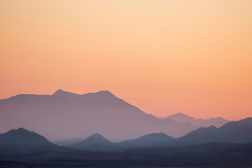 landscape of a sunrise with mountains and fields