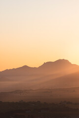 landscape of a sunrise with mountains and fields
