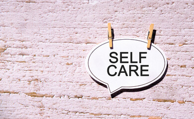 Self care on a white sheet with wooden pins