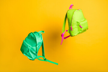 Back to school. Pair two colorful flying rucksacks thrown up by classmates groupmates summer...