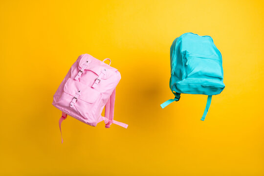 Two school bags flight on yellow color background shopping center store mall advertisement offer low prices children accessory stuff