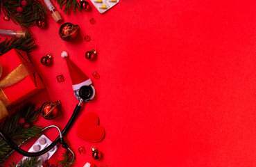 Fototapeta na wymiar Medical Christmas banner with pills, stethoscope, test tubes, gift box, Santa hat, Christmas toys, heart, and a Christmas tree on a red background. Copyspace. The new year's cure is categorical. 
