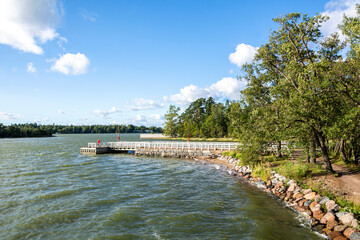 Fototapeta premium Coastal view of Seurasaari area in summer, wooden pier and Gulf of Finland, Helsinki, Finland