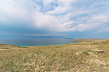 Picturesque sky over the Maloye More Strait. Federal highway on the steppe coast of Olkhon Island.