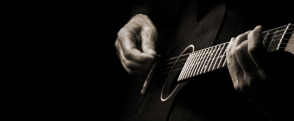 Playing an Acoustic Guitar. Guitarist hands and guitar close up. black and white. copy space