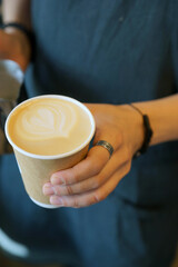 Barista prepares coffee in a paper cup