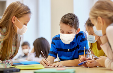 education, school and pandemic concept - group of students wearing face protective medical mask for...