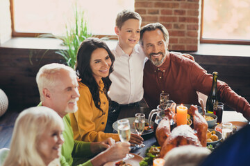 Photo of served table thanksgiving meeting parents embracing small son listen greeting toast living room indoors