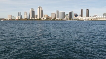 Fototapeta premium Metropolis urban skyline, highrise skyscrapers of city downtown, San Diego Bay, California USA. Waterfront buildings near pacific ocean harbour. View from boat, nautical public transport to Coronado