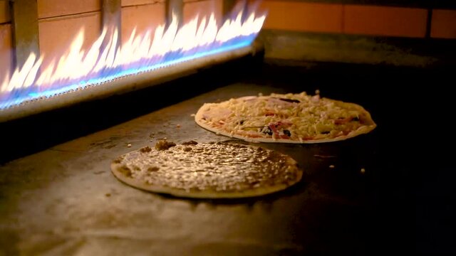 Arabic pizzas cooked inside a gas stove at a restaurant.