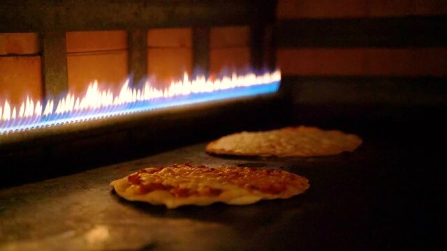 Arabic pizzas cooked inside a gas stove at a restaurant.