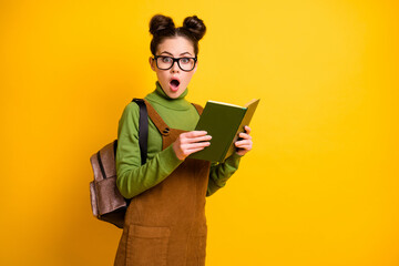 Portrait of her she nice attractive stunned wondered intellectual girl nerd reading interesting book novel science fiction isolated bright vivid shine vibrant yellow color background