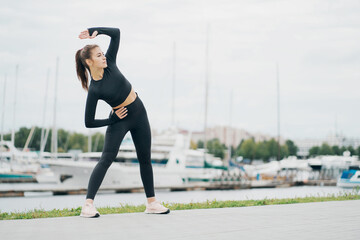 exercise aerobics healthy lifestyle. stylish tight comfortable clothing. nice weather summer day. portrait of a beautiful athletic brunette woman of Caucasian appearance.