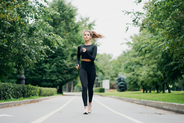 determined brunette woman of Caucasian appearance. running sports on a cross-country road. stylish...