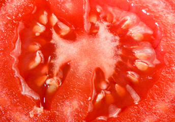 red juicy tomato cut in half with seeds inside.