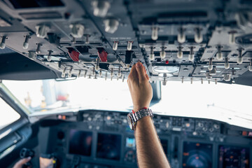 Pilot hand pushing on the dashboard in the aircraft