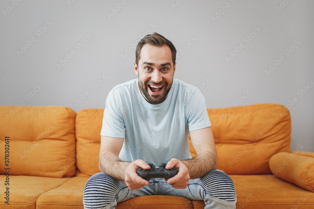 Poster excited cheerful funny handsome attractive young bearded man 20s wearing casual blue t-shirt play pc