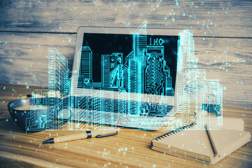 Desktop computer background in office and big town buildings hologram drawing. Double exposure. Smart city concept.