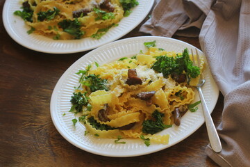 Pasta with creamy sauce, mushrooms and kale, close up