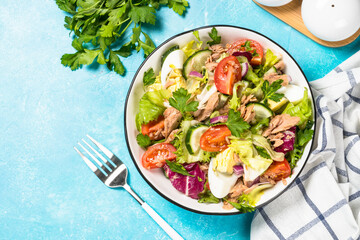 Tuna salad with green leaves, eggs and vegetables.