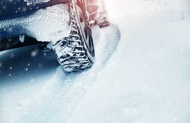 Car tires on winter road covered with snow