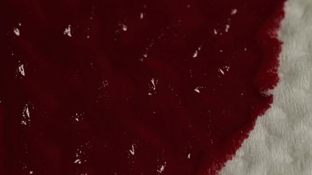 Red blood is absorbed into the paper white napkin paper, macro shot