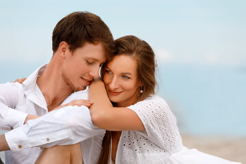 Fototapeta premium Portrait of a sweet couple of young lovers resting on the beach