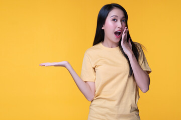Young woman with surprised excited screaming while holding hand with product on sale promotion over...