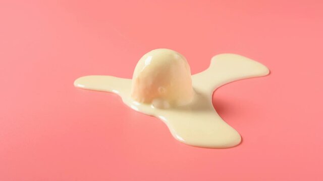 side view vanilla flavor ice cream ball melting timelapse on a pink background