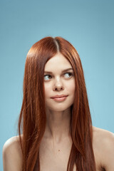 Fototapeta premium Beautiful brunette long hair naked shoulders cosmetics charm health care blue background