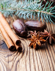 Christmas winter spices and blue pine tree branch on wooden background. Close up. Copy space.