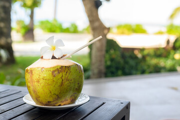 A coconut on the wooden table in a Cozy bungalow with Green tropical garden on phi phi island,...