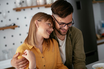 Young couple making breakfast at home. Loving couple eating cereal in kitchen..