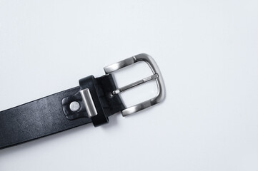 Metal buckle of  male black leather belt on a white background close-up.