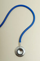 Top view of blue stethoscope in question shape on the bright surface.Concept of pending issues in...