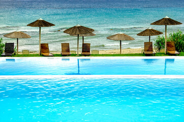 Luxury swimming pool and sunbeds with view to the sea